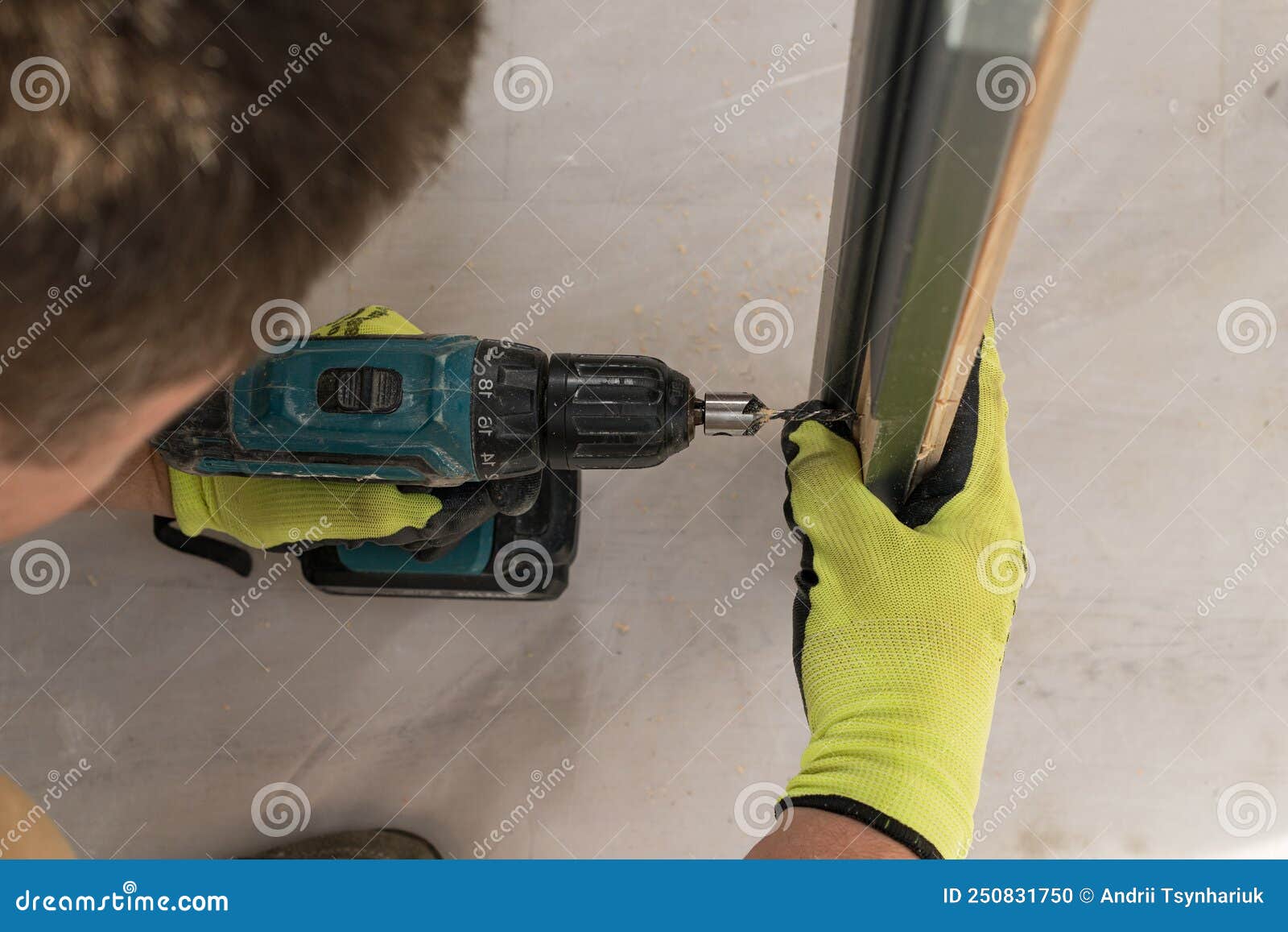 Drilling a Hole in the Door with a Green Screwdriver, Closeup of the