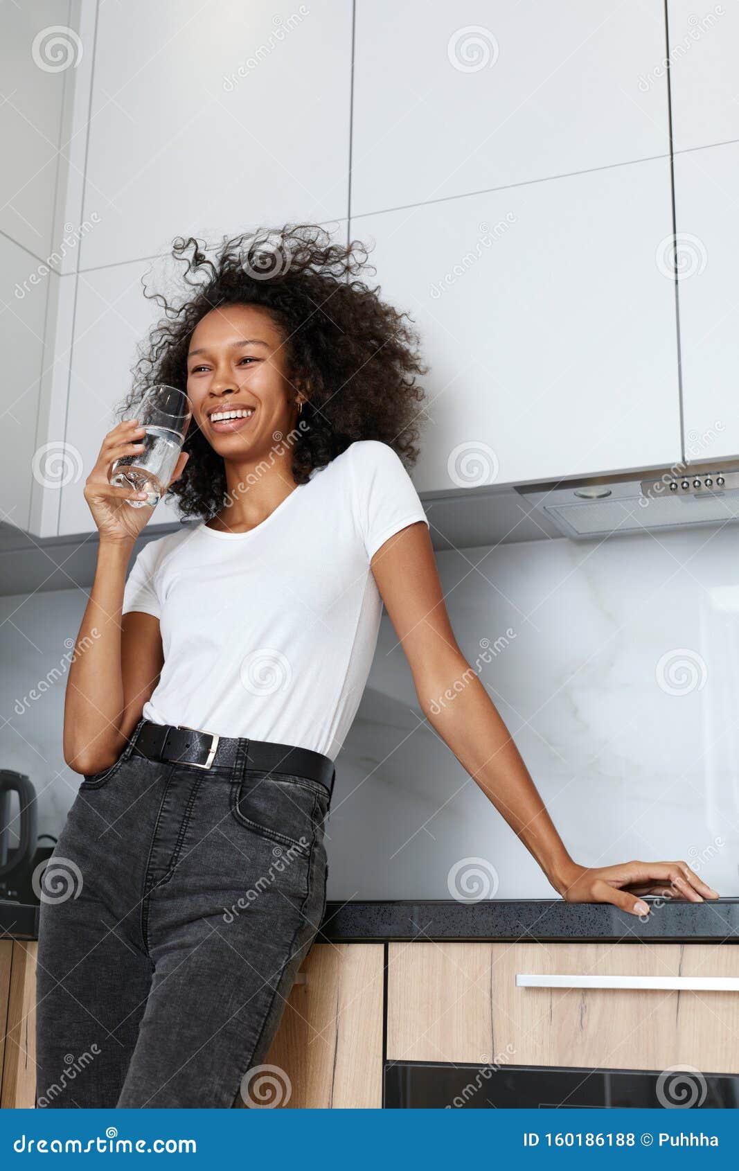 drink water. happy woman with glass of fresh water in kitchen