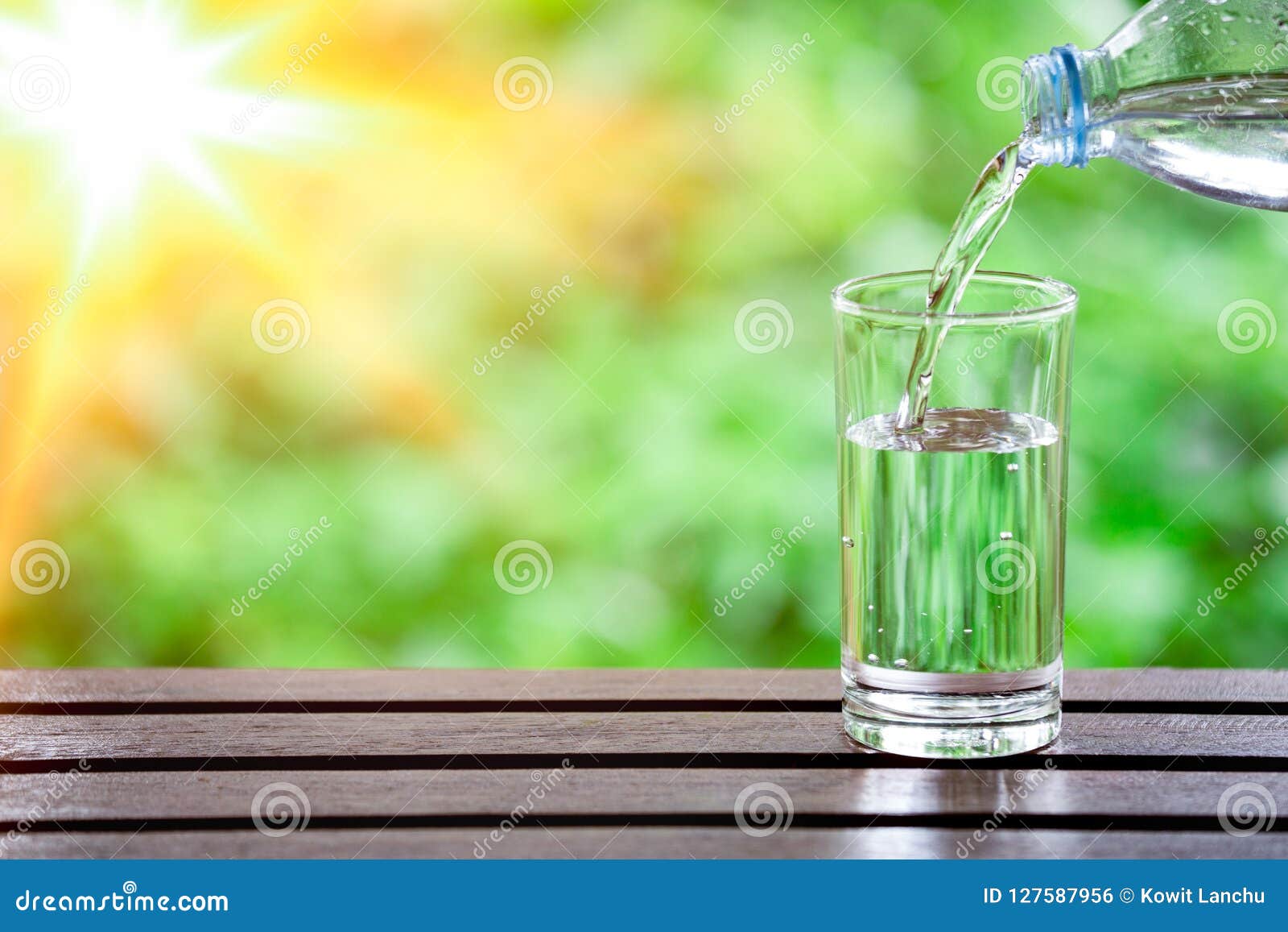 Drink Water Pouring into Glass on Wooden Table Over Sunlight with Natural  Lighting and Background Texture Stock Photo - Image of lighting, hand:  127587956