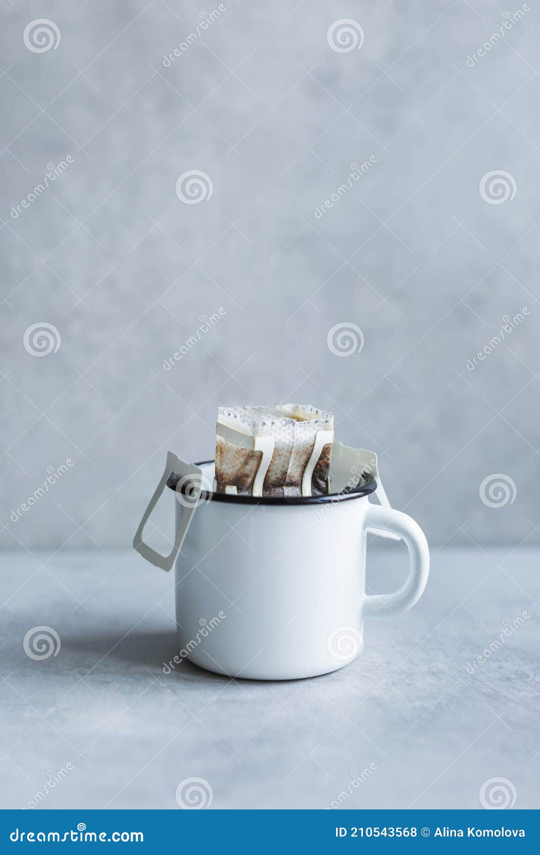 drip or brewed coffee on gray background, paper dripping bag on a white cup. specealty coffee at home