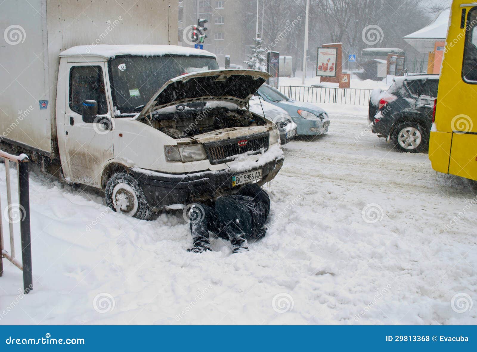 The Driver of the Car Repairs Lying in the Snow Editorial Stock Photo
