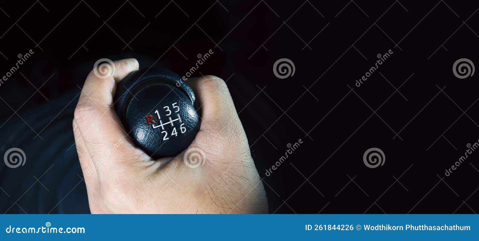the driver hand is shifting the gears of a 6-speed manual transmission