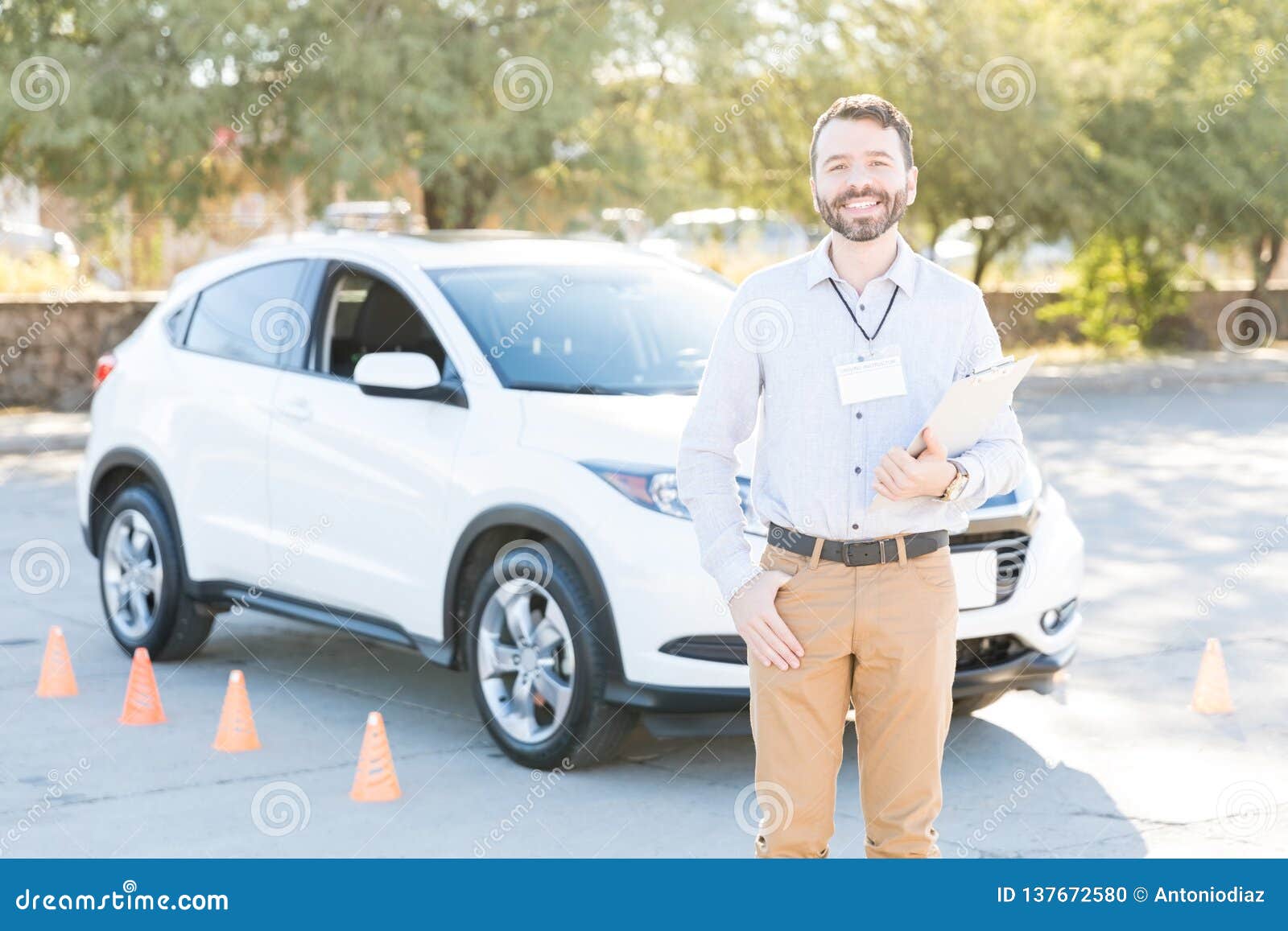 driving teacher smiling against car