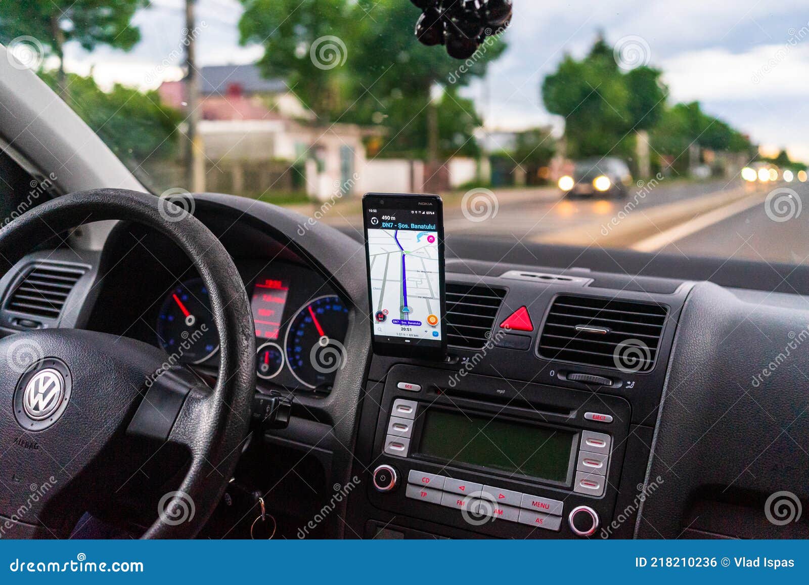 Driving And Using Waze Maps Application On Smartphone On Car Dashboard