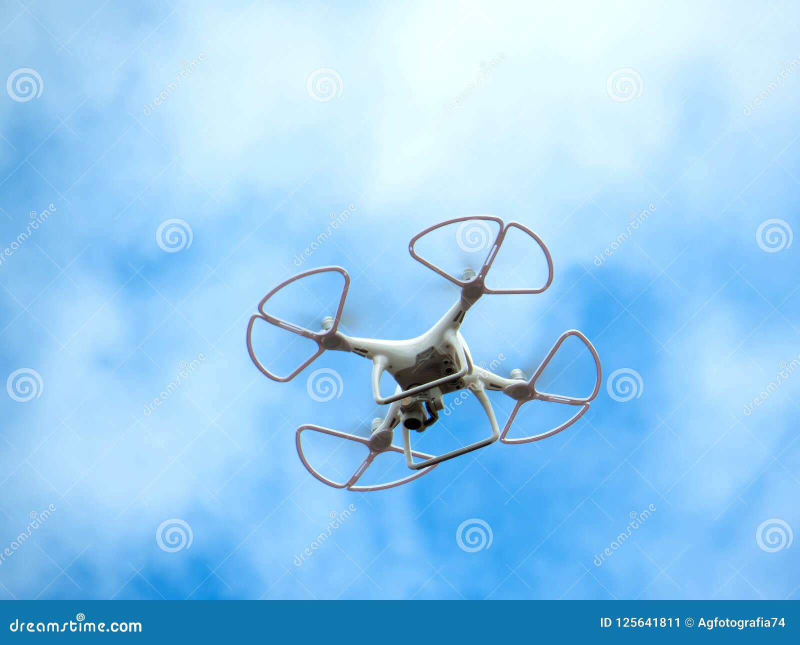 Drone in Flight Isolated on Blue Sky with Clouds Stock Image - Image of