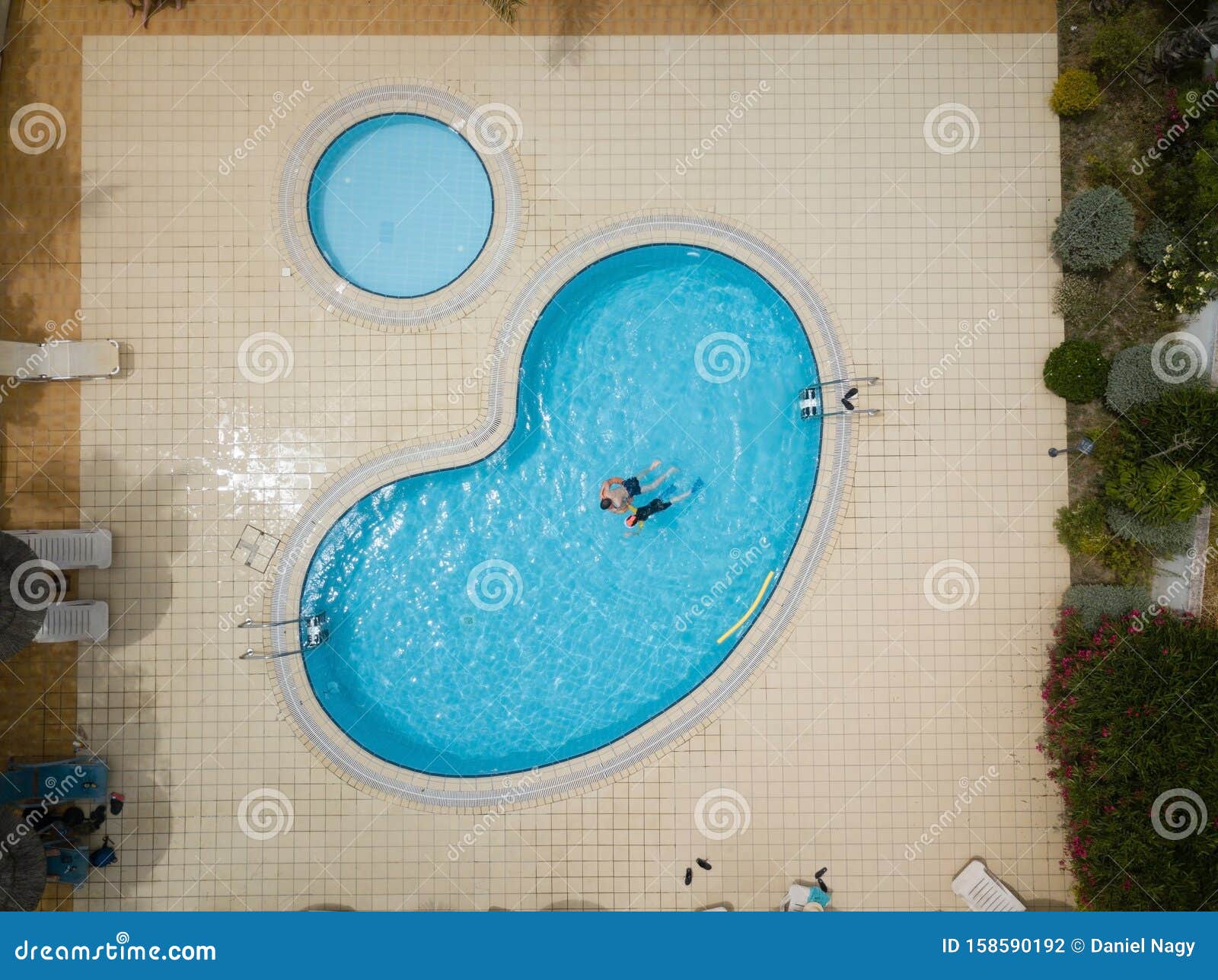 Drone Image Birds Eye View About A Blue Swimming Pool With Playing