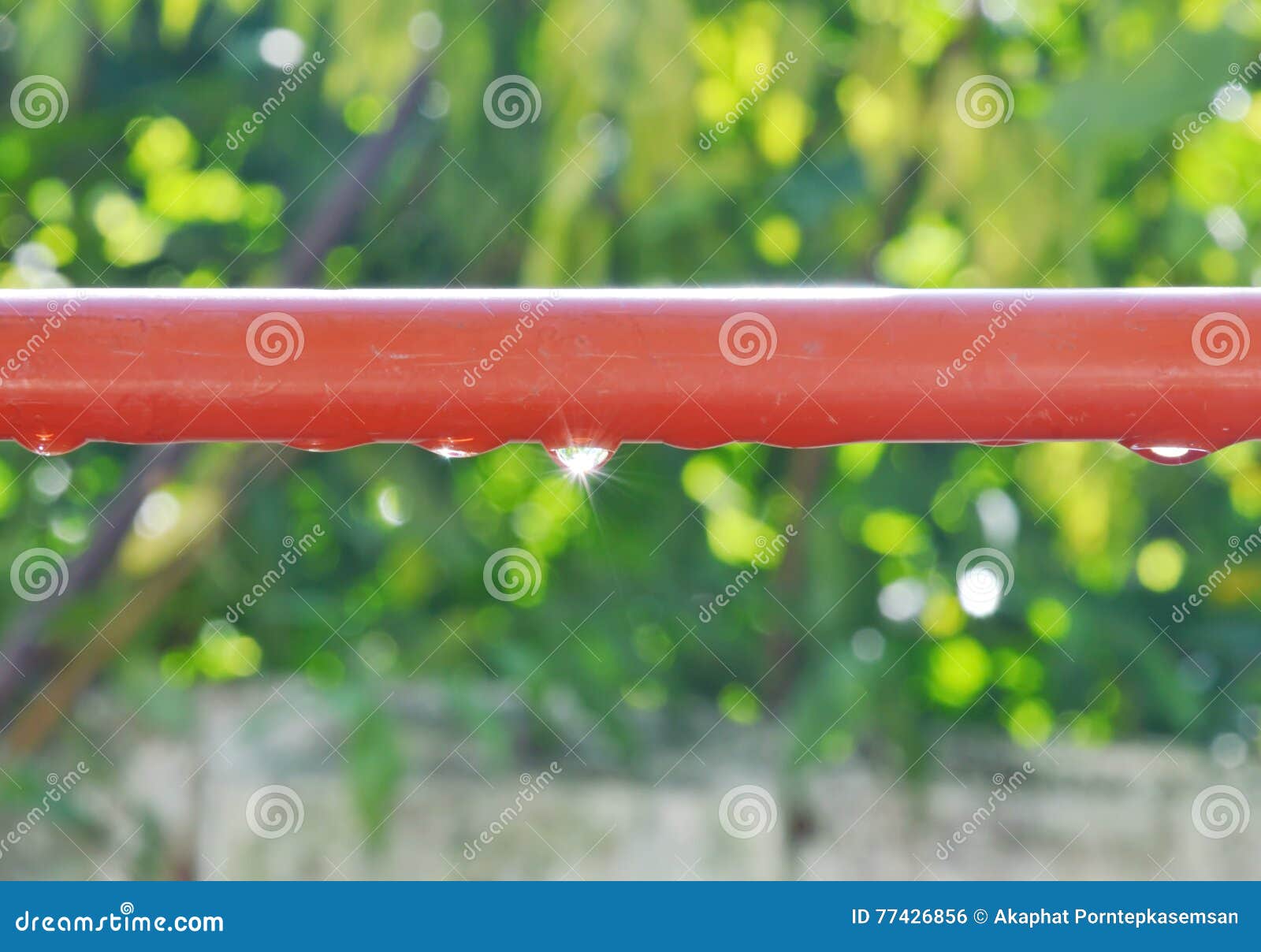 Drop of Water on Red Aluminum Clothes Line Reflection Sunlight Stock