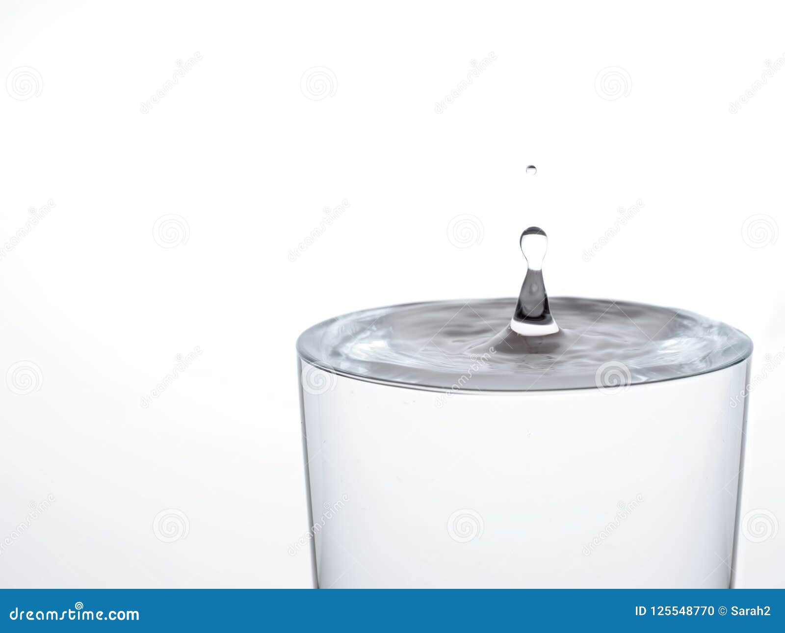 drop of water, about to make the glass overflow and run over. on white.