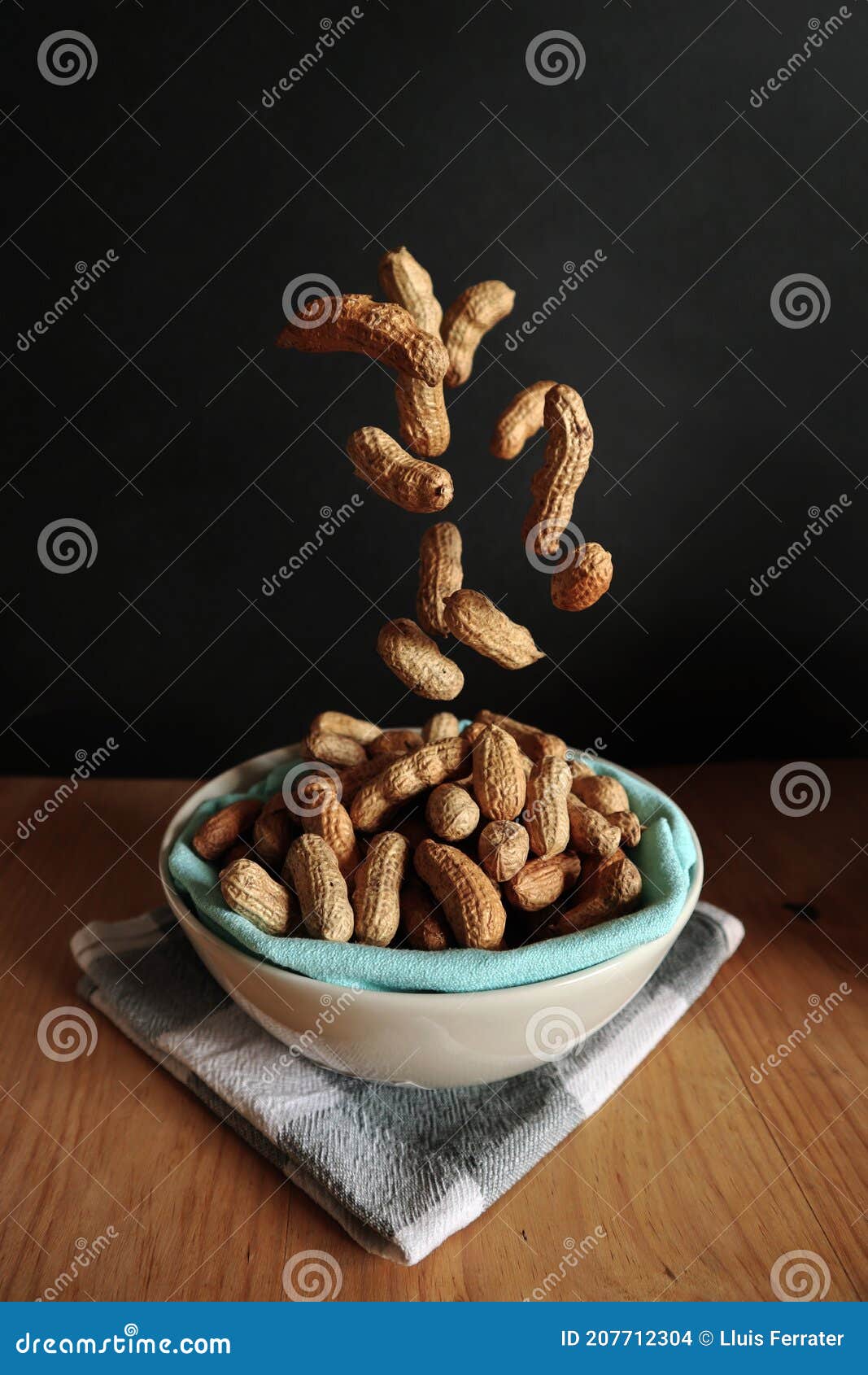Dropping peanuts in a bowl stock photo. Image of nutrient 207712304