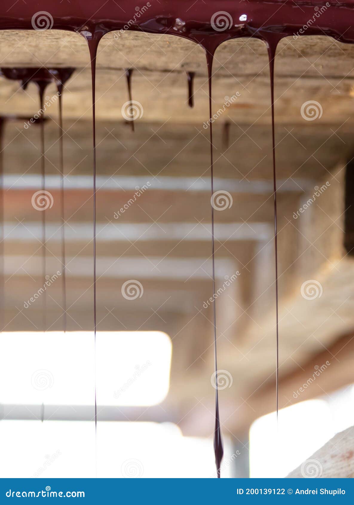 Drops of Brown Paint Dripping from the Wooden Ceiling Stock Photo