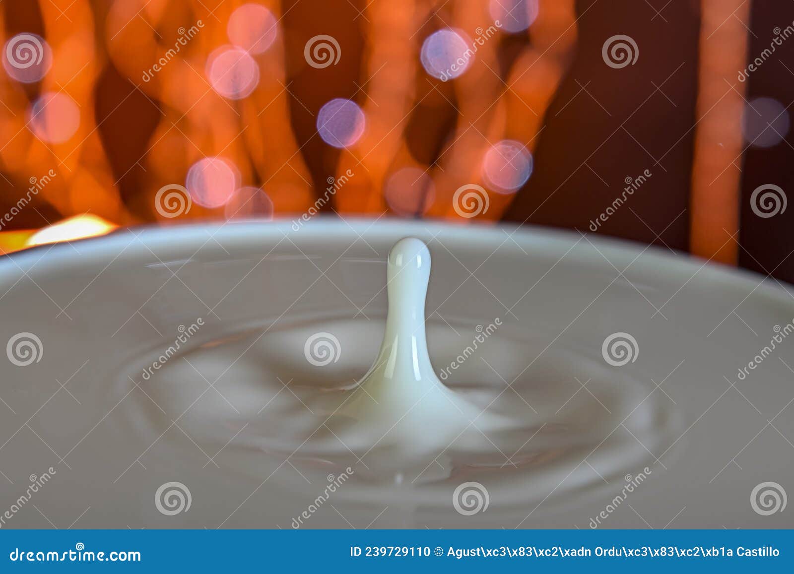 drops falling on a container, with a bokeh background.