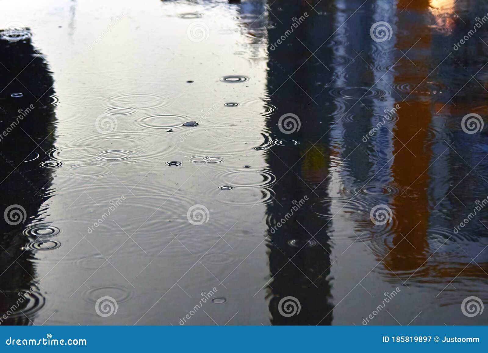 Drops of Rain Bubbling in a Puddle with the Reflection of Light Stock