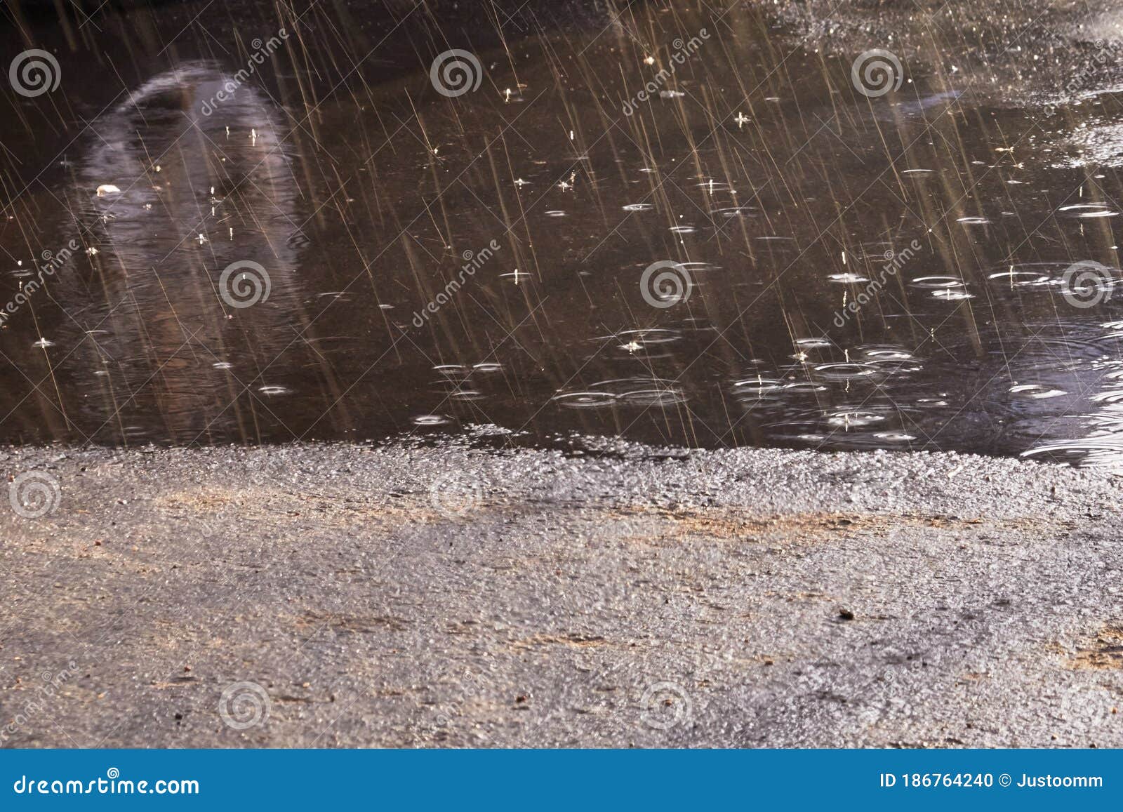 Drops of Rain Bubbling in a Puddle with the Reflection of Light Stock