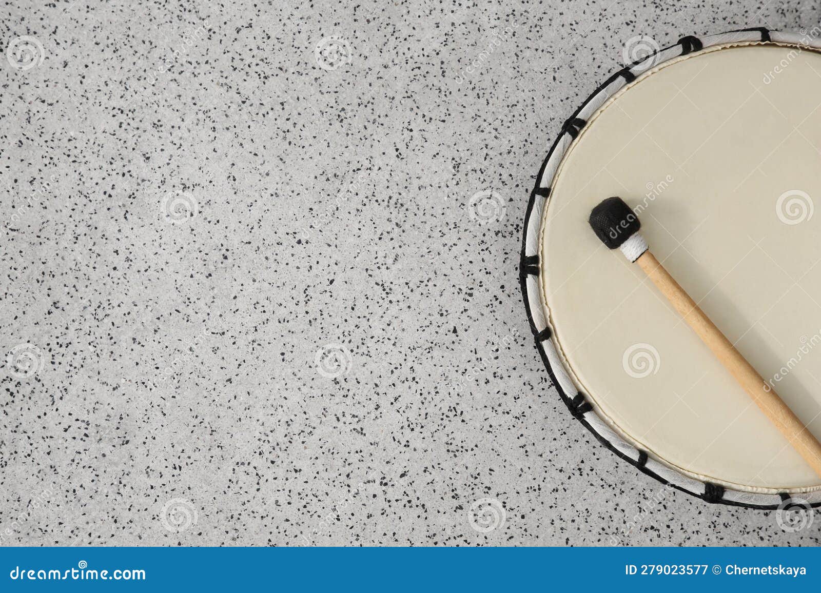 Drum and Drumstick on Grey Table, Top View with Space for Text