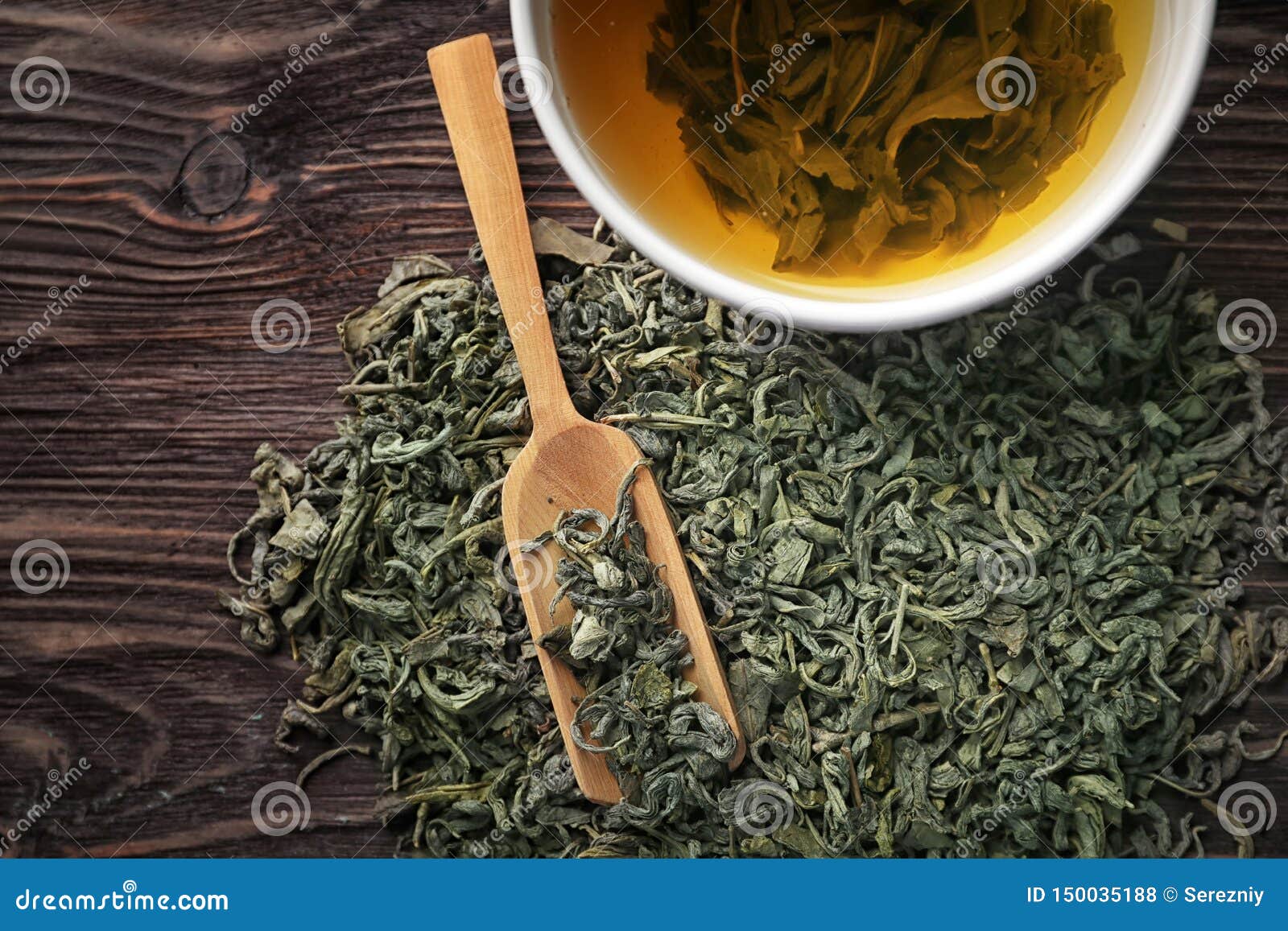 Dry Green Tea Leaves and Cup of Aromatic Beverage on Table Stock Photo
