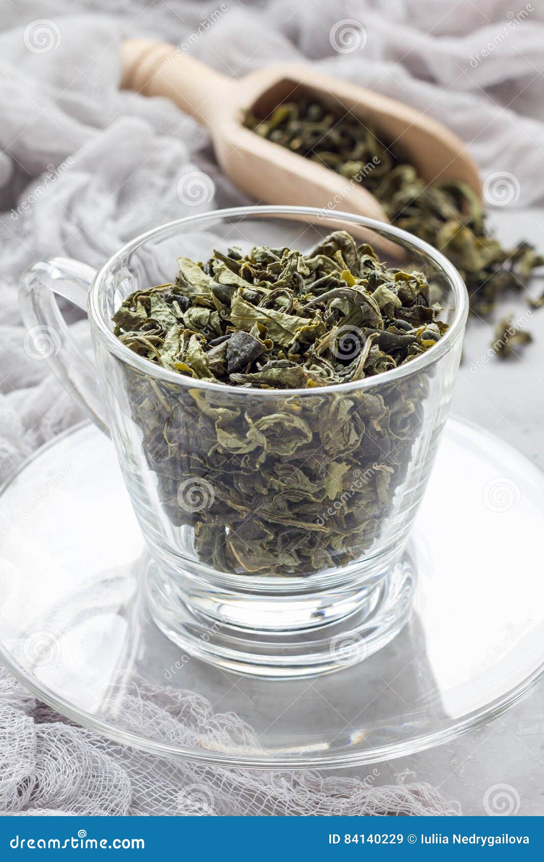 Dry Green Tea Leaves in Cup and on Background, Vertical Stock Image