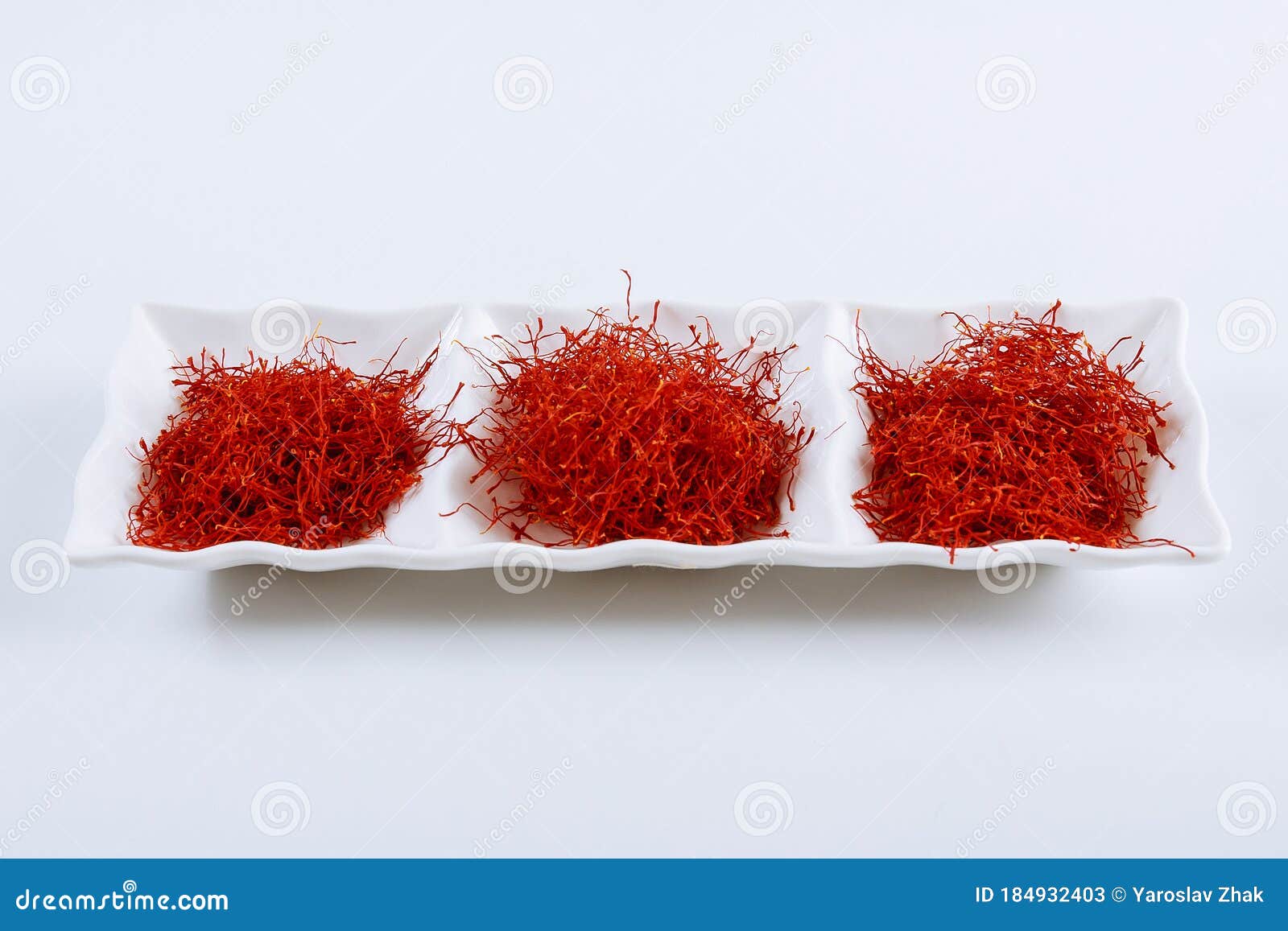 dry saffron spice on a white plate on white background