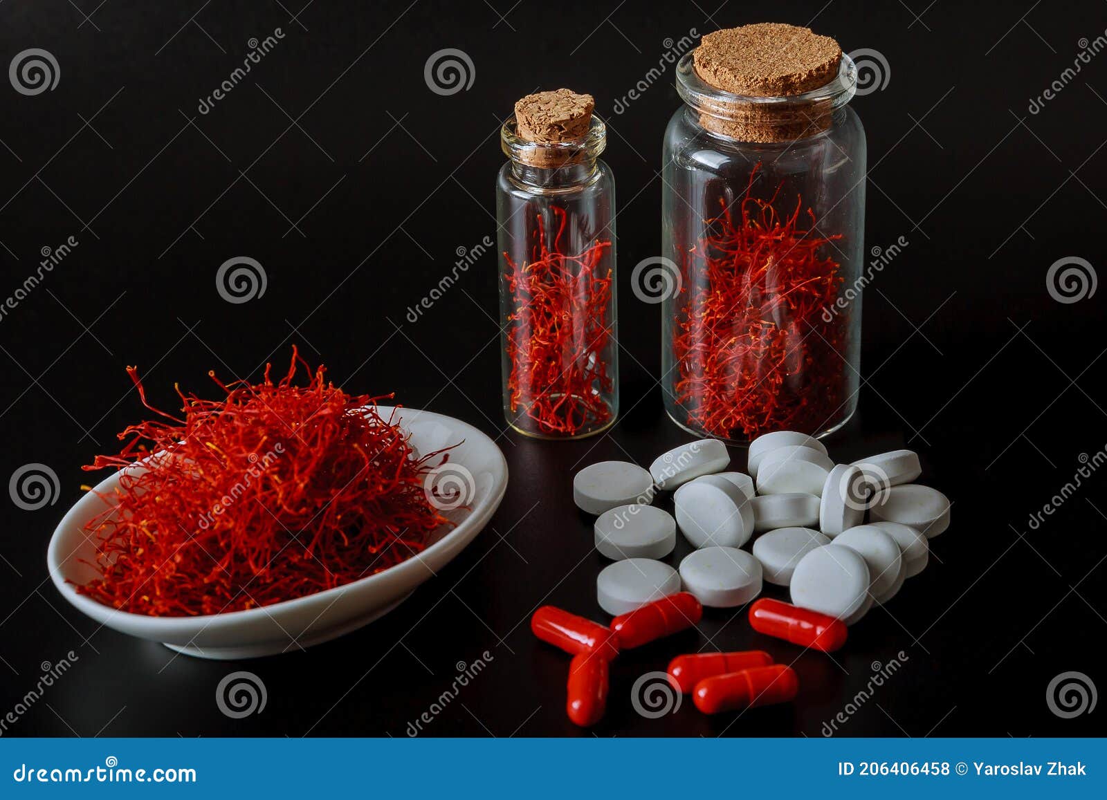 dry saffron threads and pills on a white background. the use of saffron in medicine