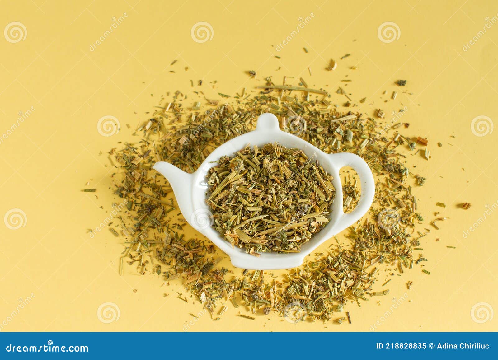 dry tea from medicinal plants   on a teapot-d plate on yellow background