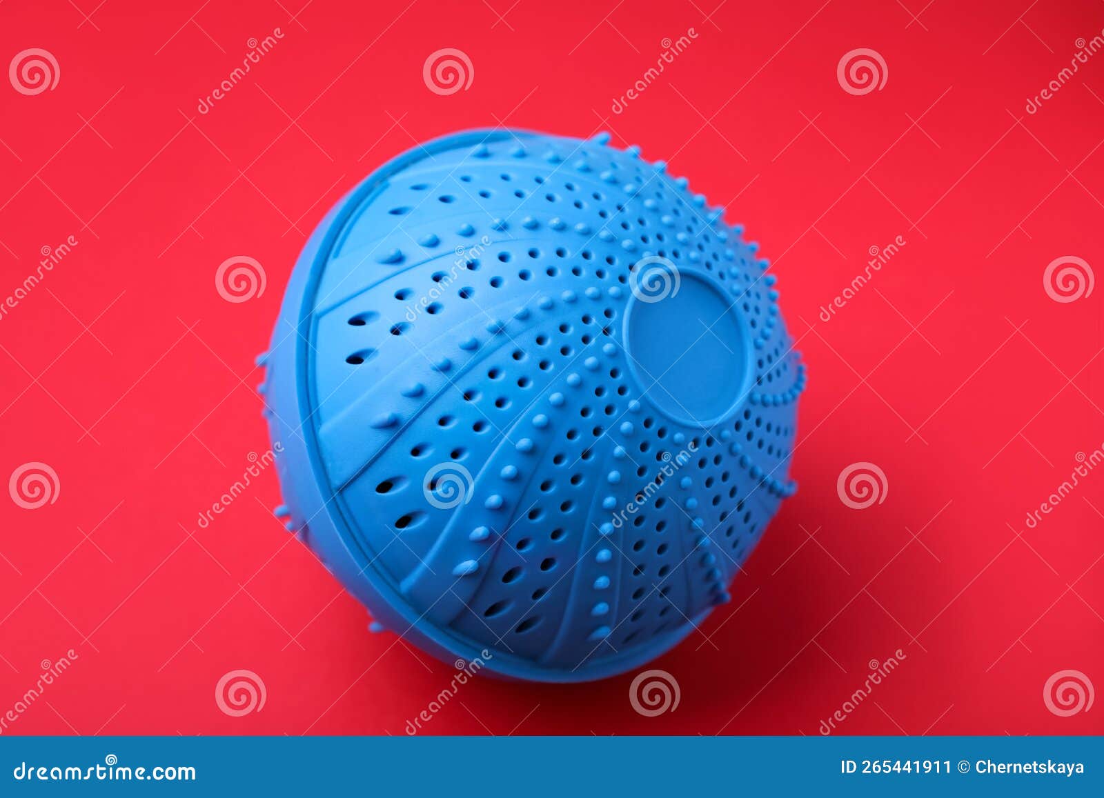 Dryer Ball for Washing Machine on Red Background. Laundry Detergent