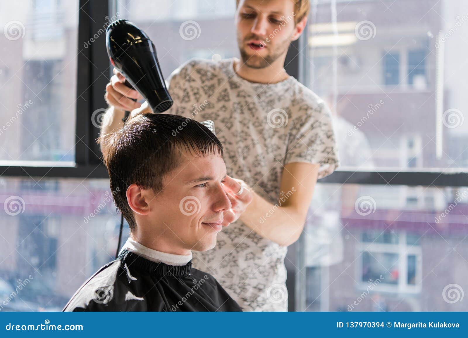 Drying, styling men`s hair in a beauty salon.