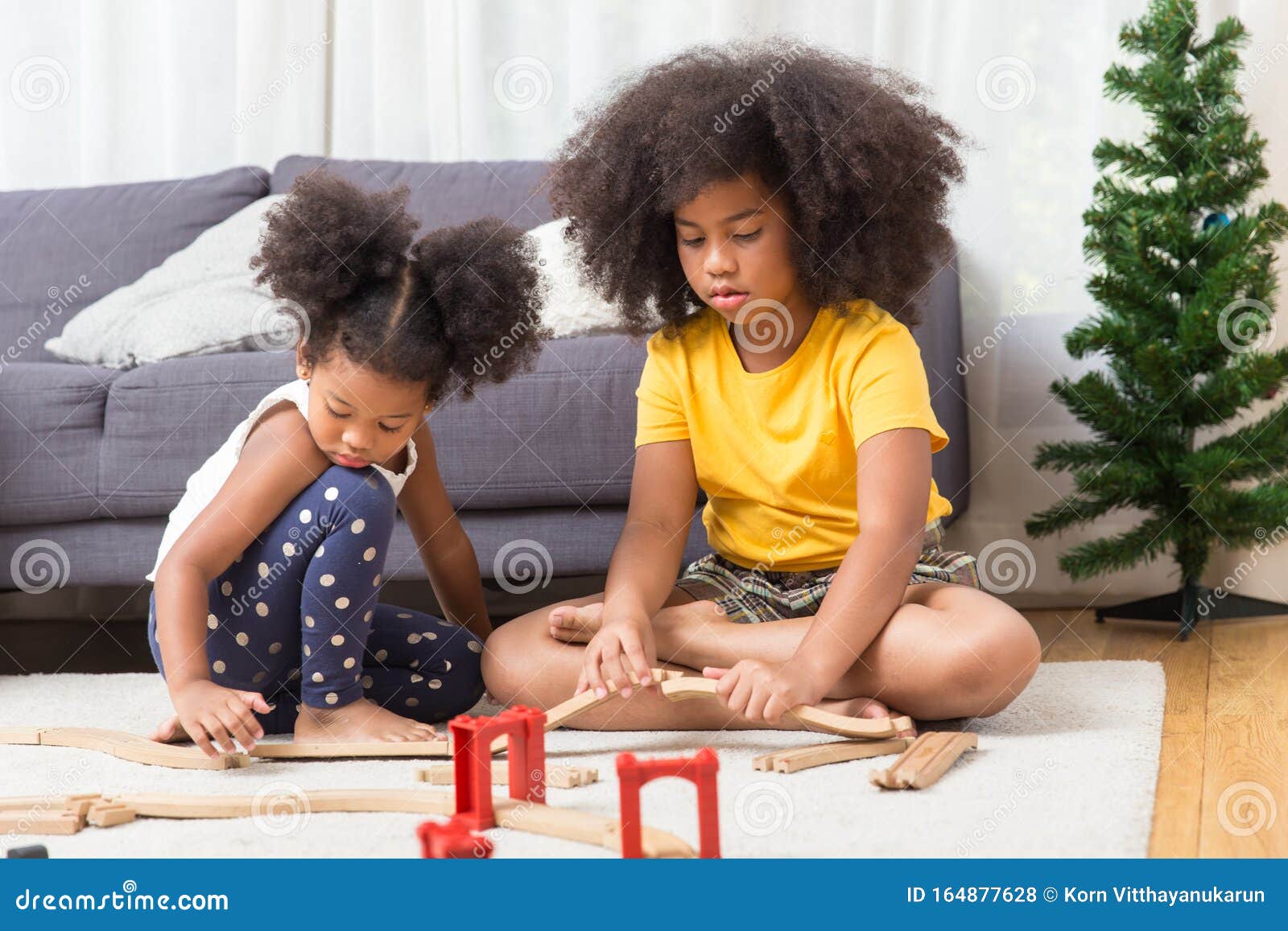 Foto Namoradinhas negras sentadas em banco de madeira e brincando ao ar  livre. Conceito de infância. Ideia de amizade. Estilo de vida infantil  moderno. Meninas morenas cacheadas alegres. Ensolarado durante o dia –