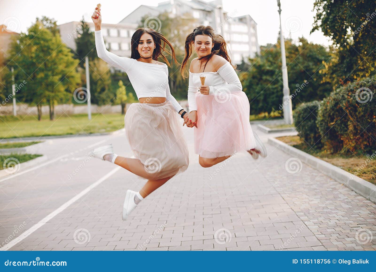 Duas Meninas Bonitas Jovens Em Um Passeio No Parque Com Telefones. Dia De  Verão Ensolarado Quente, Alegria E Amizades. Foto Royalty Free, Gravuras,  Imagens e Banco de fotografias. Image 141195885