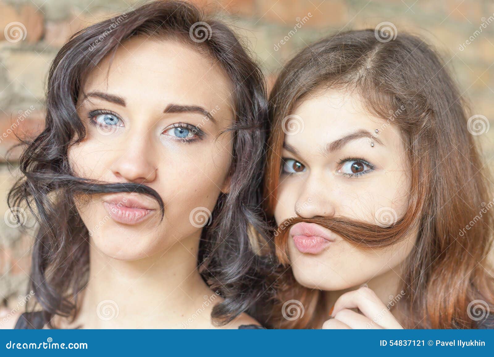 Duas Meninas Bonitas Novas Que Fazem O Bigode De Seu Cabelo Imagem de Stock  - Imagem de bonito, feliz: 54837121