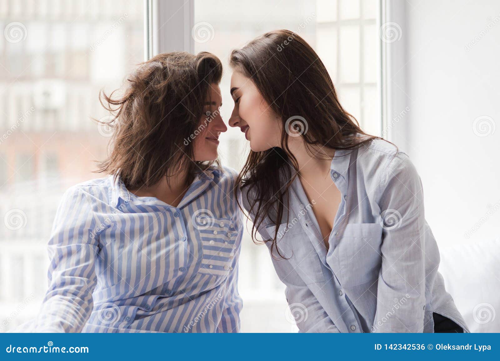 Duas Meninas O Mesmo Sexo Que Vai Beijar Na Venda Da Janela Foto de Stock foto