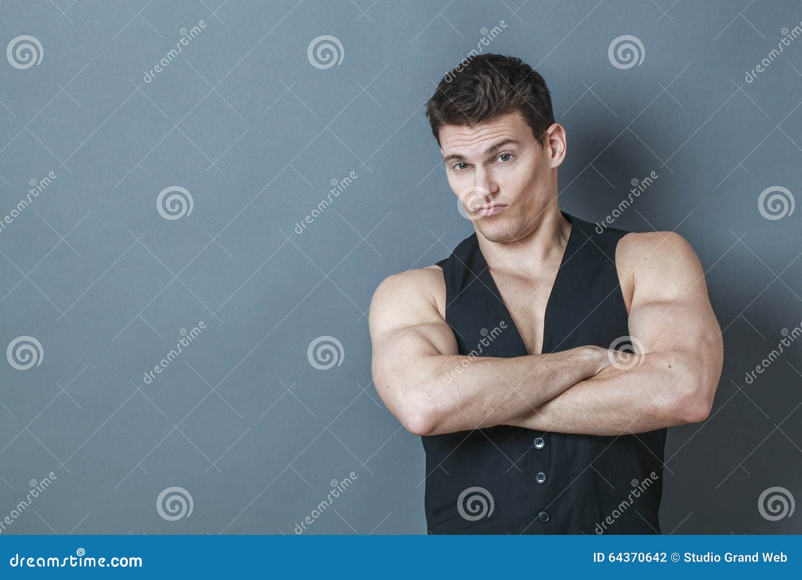 dubious young man showing his arrogant muscular strength