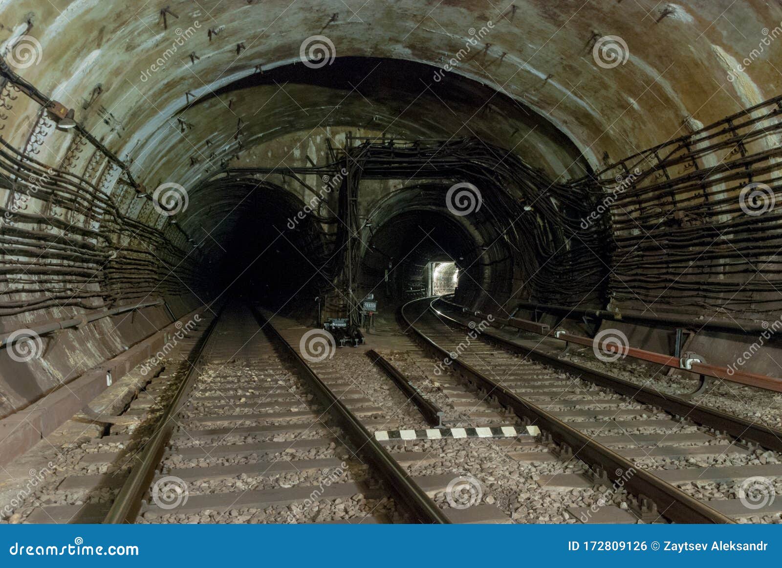 duble-track reinforced concrete tunnel of the metro line.one of the railway lines turns of the right.