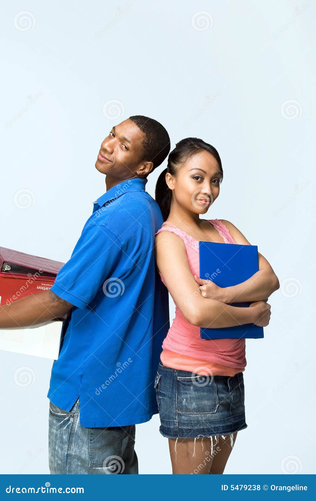 Due anni dell'adolescenza si levano in piedi indietro per appoggiare - il verticale. Due adolescenti che si levano in piedi di nuovo ai taccuini posteriori della holding stanno sorridendo. Fotografia verticalmente incorniciata