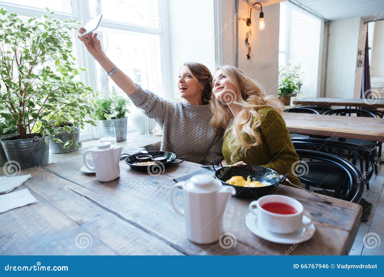 Due donne che fanno la foto del selfie sullo smartphone. Due donne felici che fanno la foto del selfie sullo smartphone in caffè