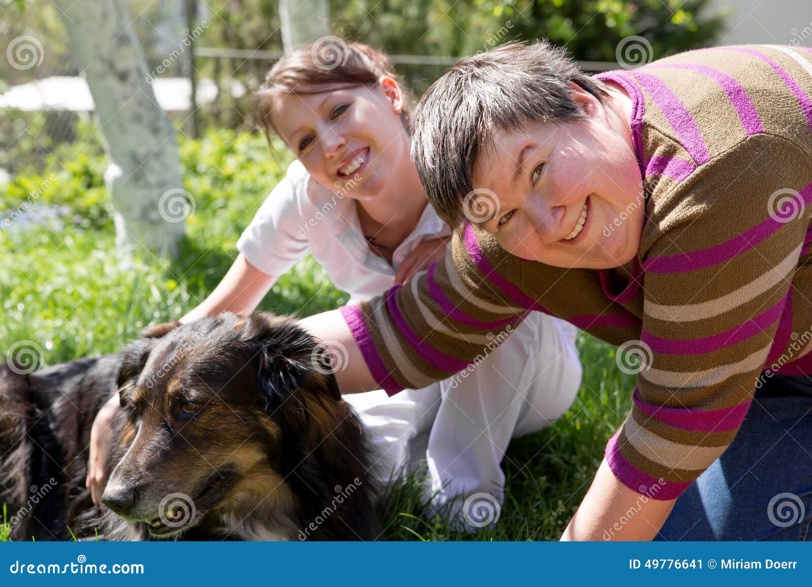 Due donne e un mezzo cane della razza su un campo