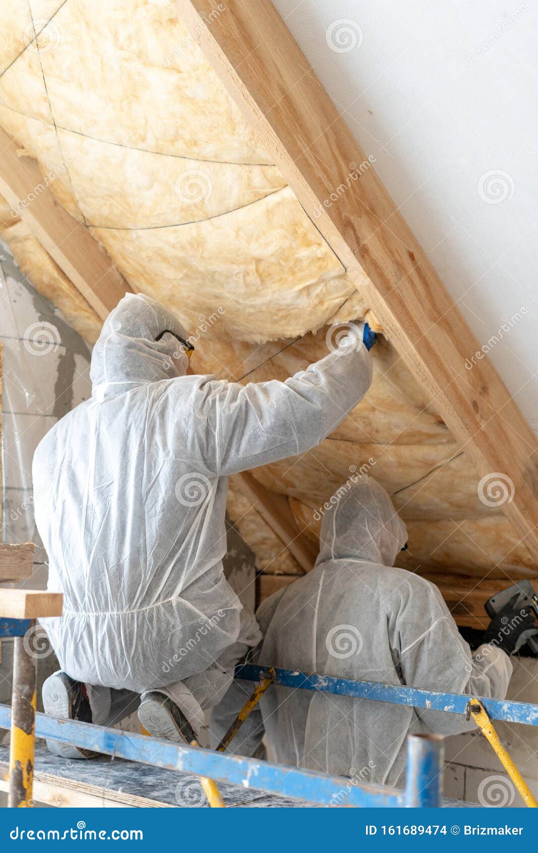 Due Muratori Professionisti Che Installano La Lana Di Roccia Isolante  Termica Sotto Il Tetto Fotografia Stock - Immagine di strato, vetro:  161689474