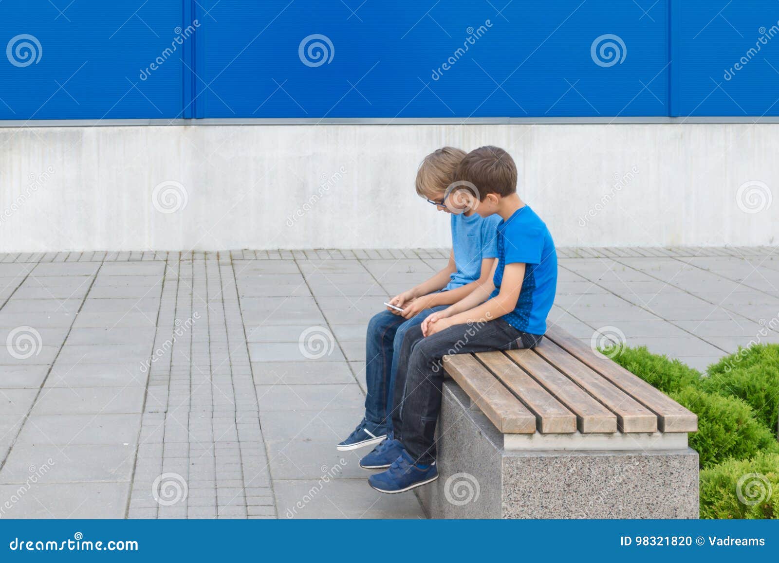 На ступеньку вскакивает хлопчик. Мальчик сидит на скамейке. Мальчик сидит на скамье. Два мальчика на скамейке. Два подростка сидят на скамейке.