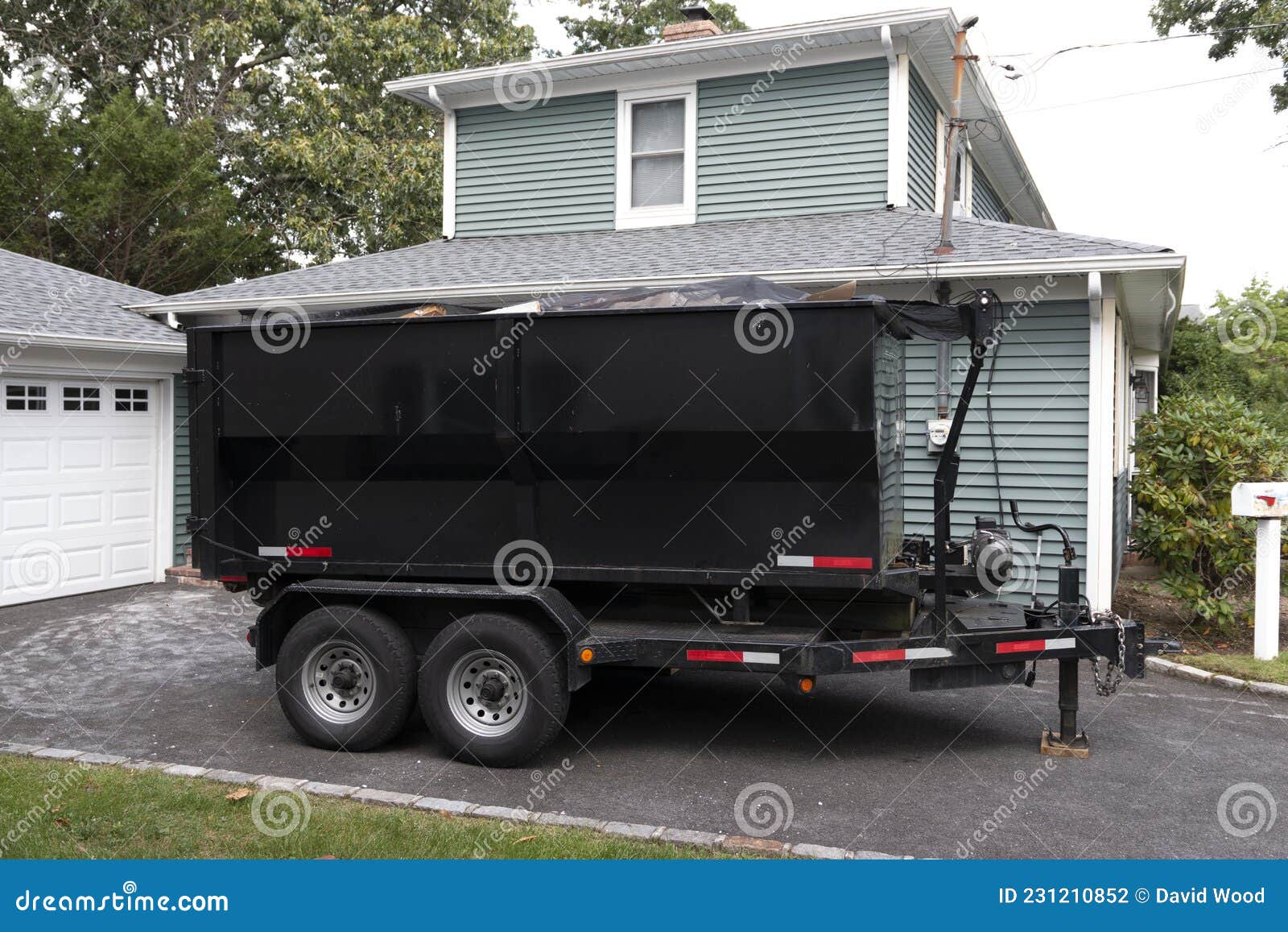 dumpster on a trailer in a residential driveway