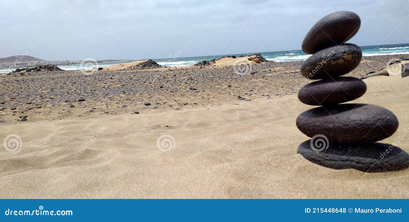 dune di sabbia desertica in spiaggia con pila di sassi zen