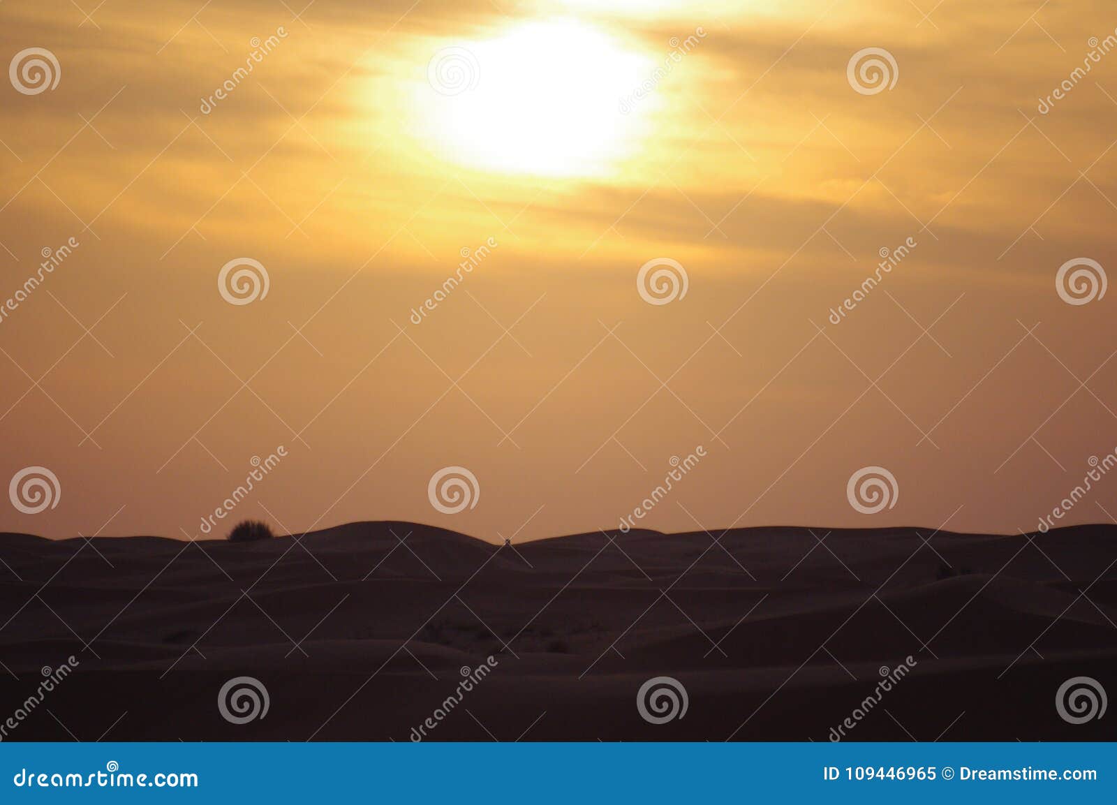 Dunes de désert au coucher du soleil avec le nuage. Un paysage dunaire mystérieux au coucher du soleil avec le ciel coloré dans le désert de Dubaï