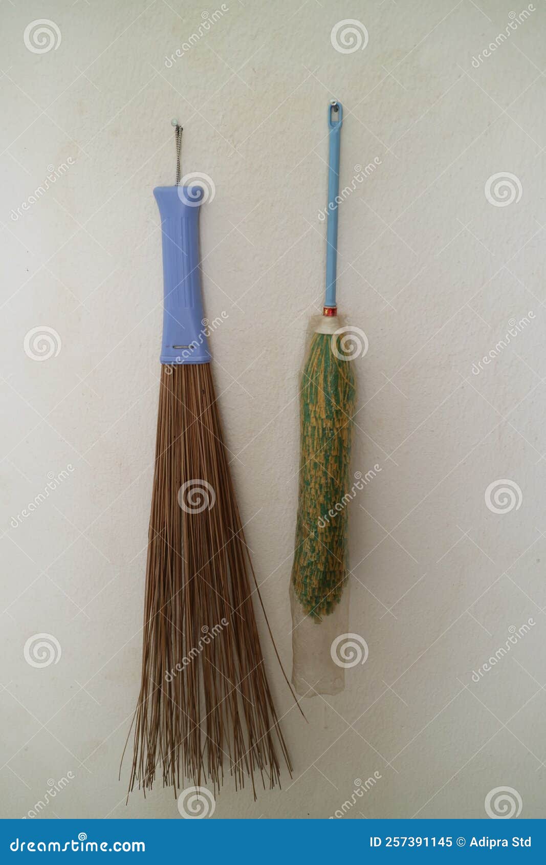 Duster and Broom Stick Hanging on the Wall of the House Stock Image