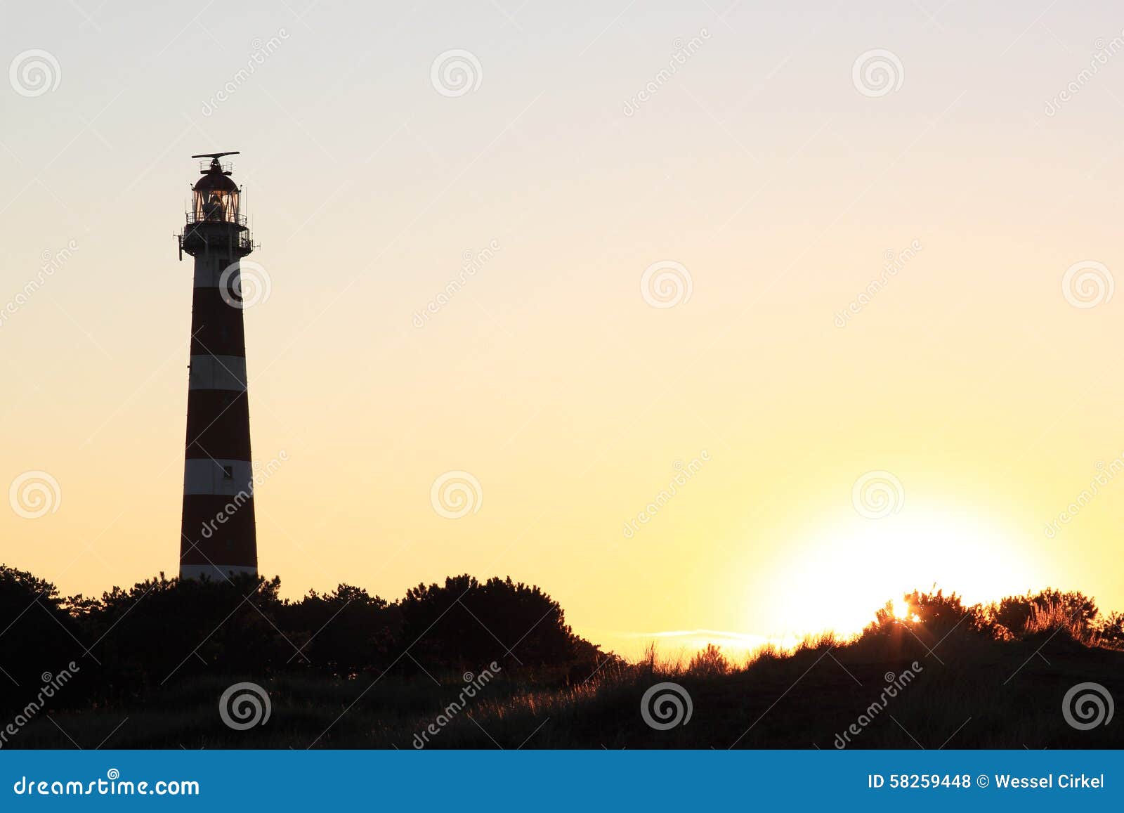 dutch lighthouse bornrif in ameland dunes at sunset