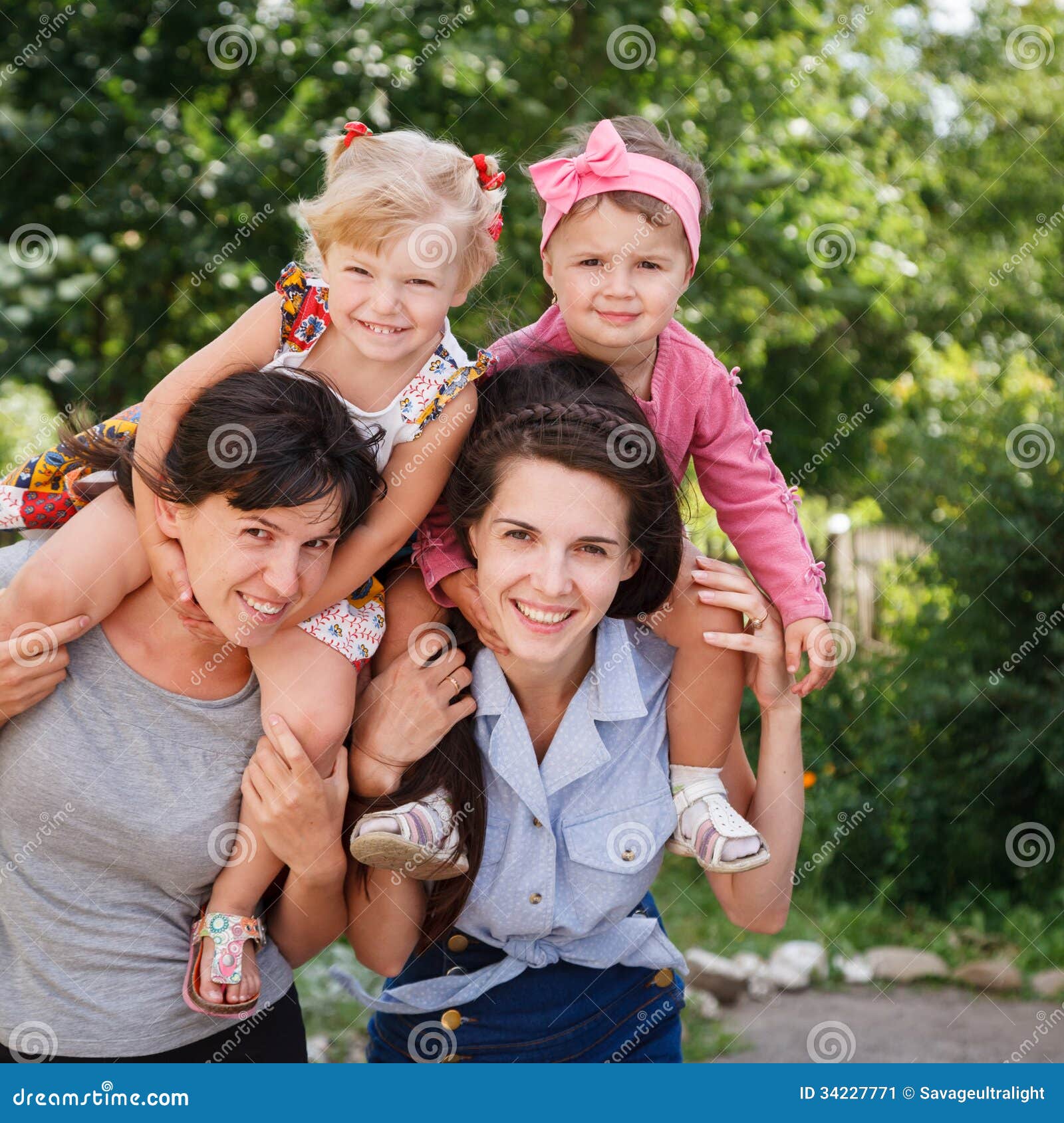 Dwa mums z ich dzieciakami. Dwa mums daje ich dzieciaków piggyback przejażdżki outdoors