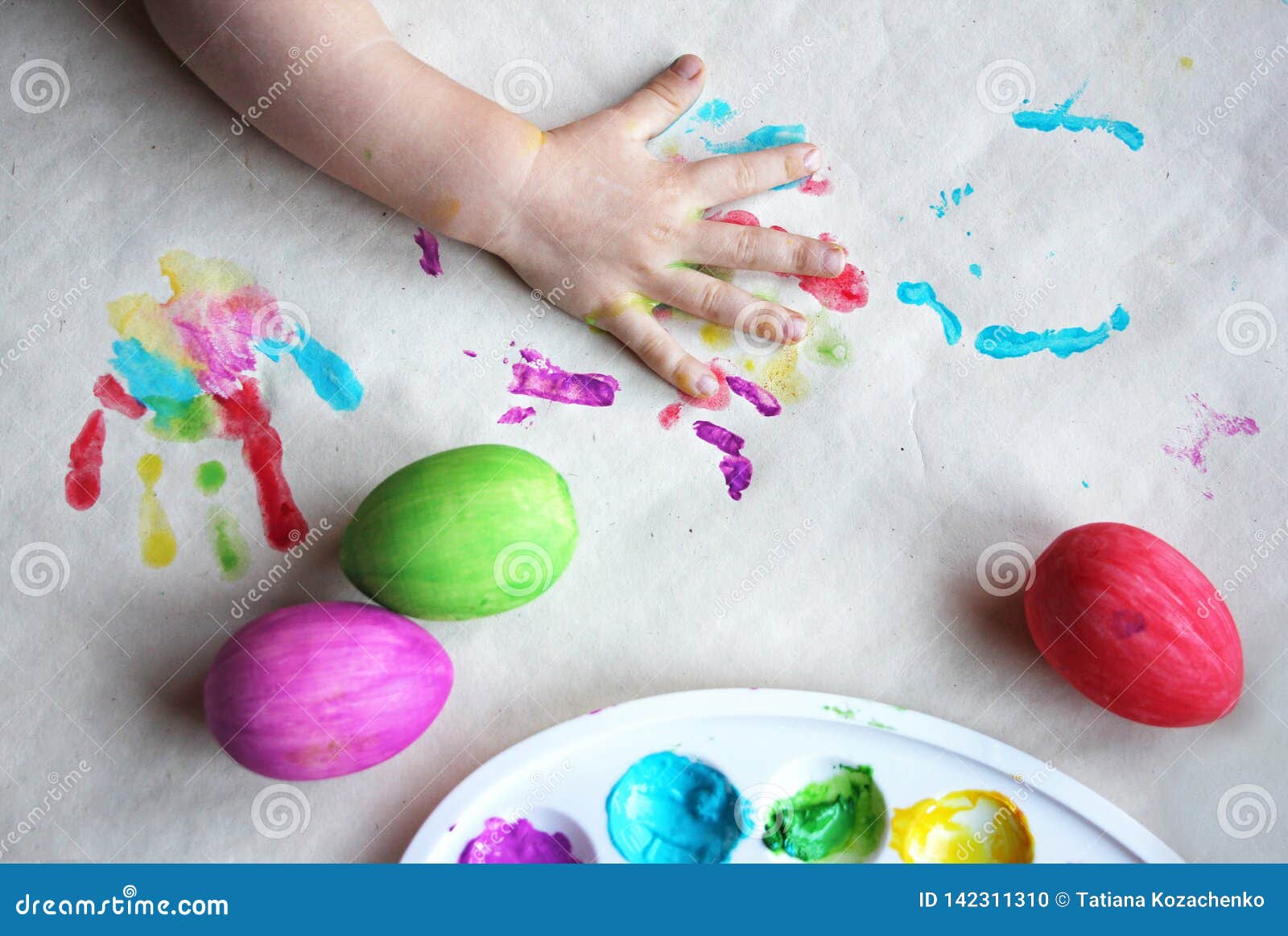 Dyeing Easter Eggs. Paints in Palette, Colorful Eggs and Child Palm on