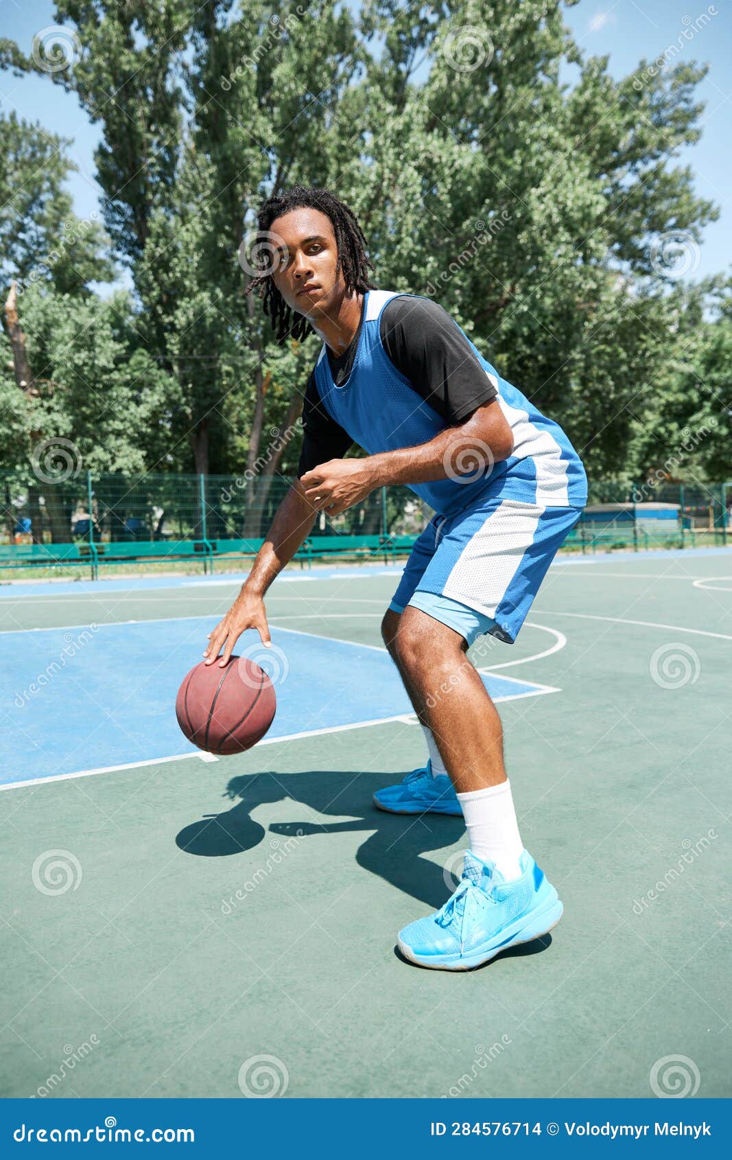Dynamic Image of Young Man, Basketball Player in Blue Uniform, Training