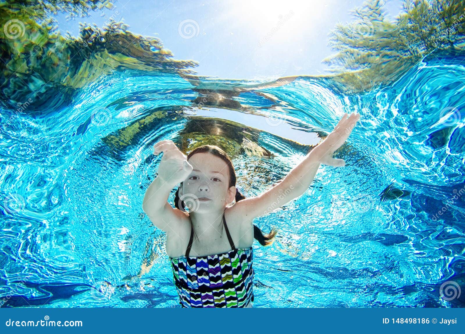 Happy active underwater child swims in pool Stock Photo