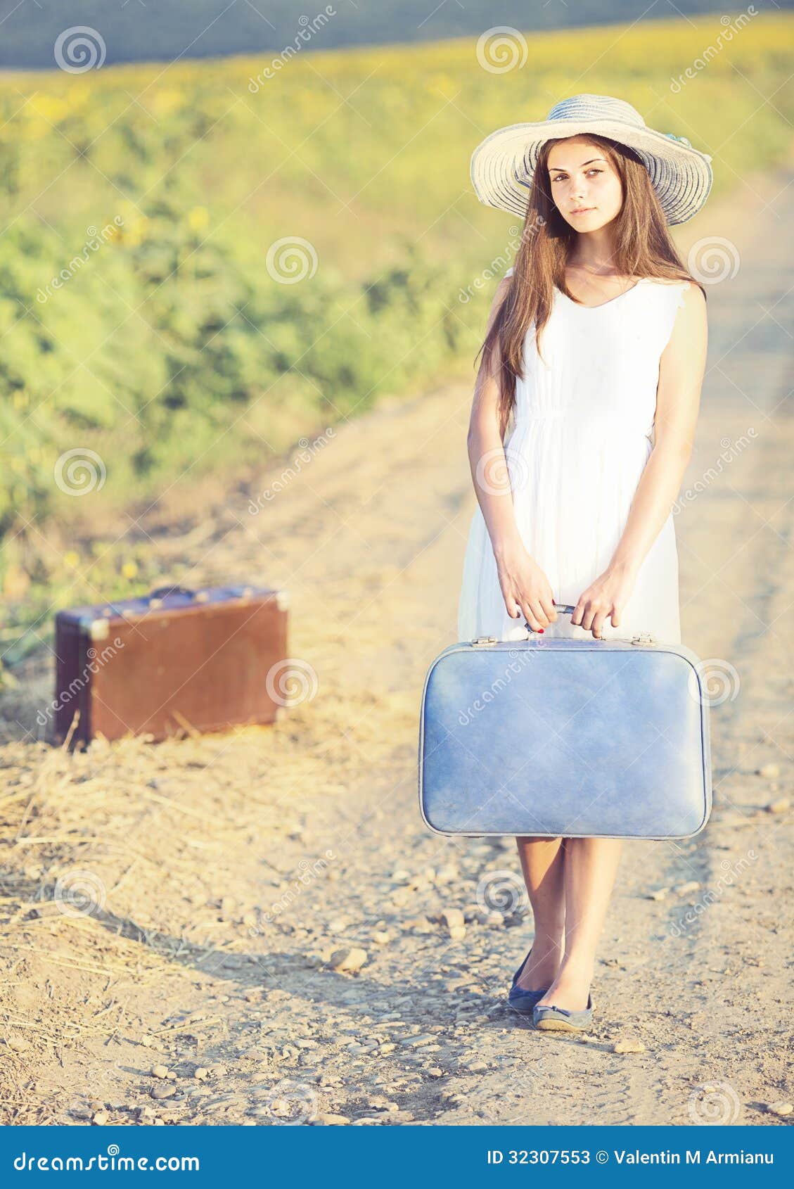 Dziewczyna z walizką na wiejskiej drodze