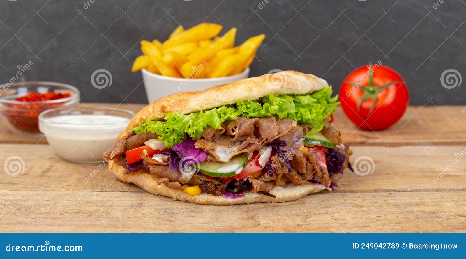 dÃÂ¶ner kebab doner kebap fast food in flatbread with fries on a wooden board panorama