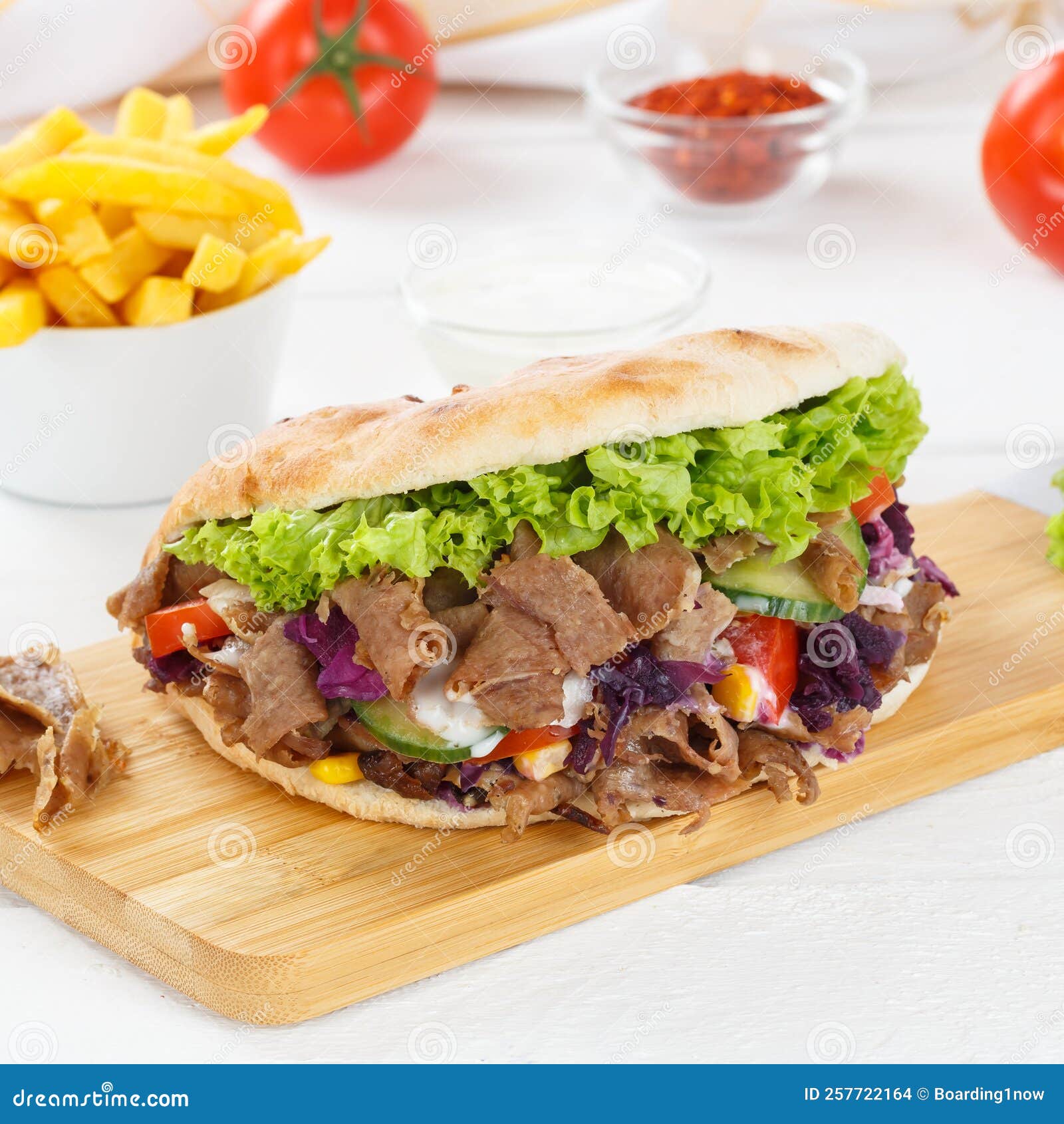 dÃÂ¶ner kebab doner kebap fast food meal in flatbread with fries on a kitchen board square