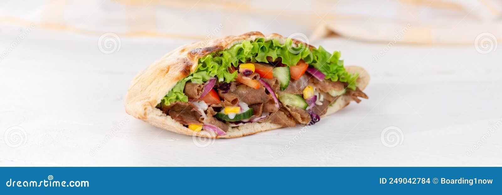 dÃÂ¶ner kebab doner kebap slice fast food in flatbread on a wooden board panorama