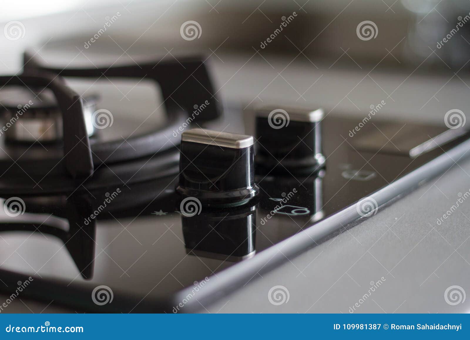 Détail de fraise-mère de gaz d'acier inoxydable sur le plan de travail en pierre noir, plan rapproché, petite et grande, surface réfléchie du brûleur deux élégant noir mat Focuse sélecteur